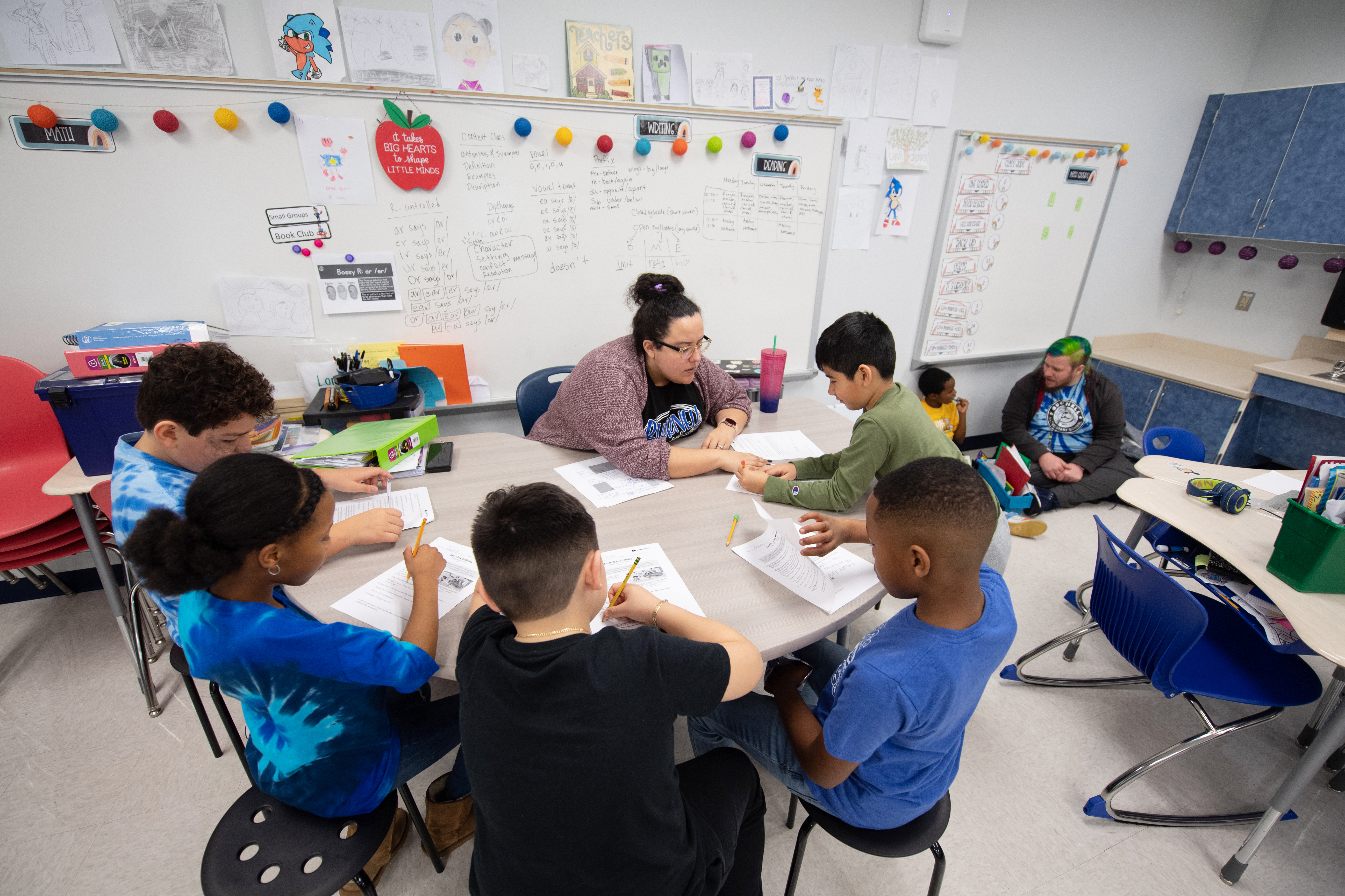 students working with teacher in small group