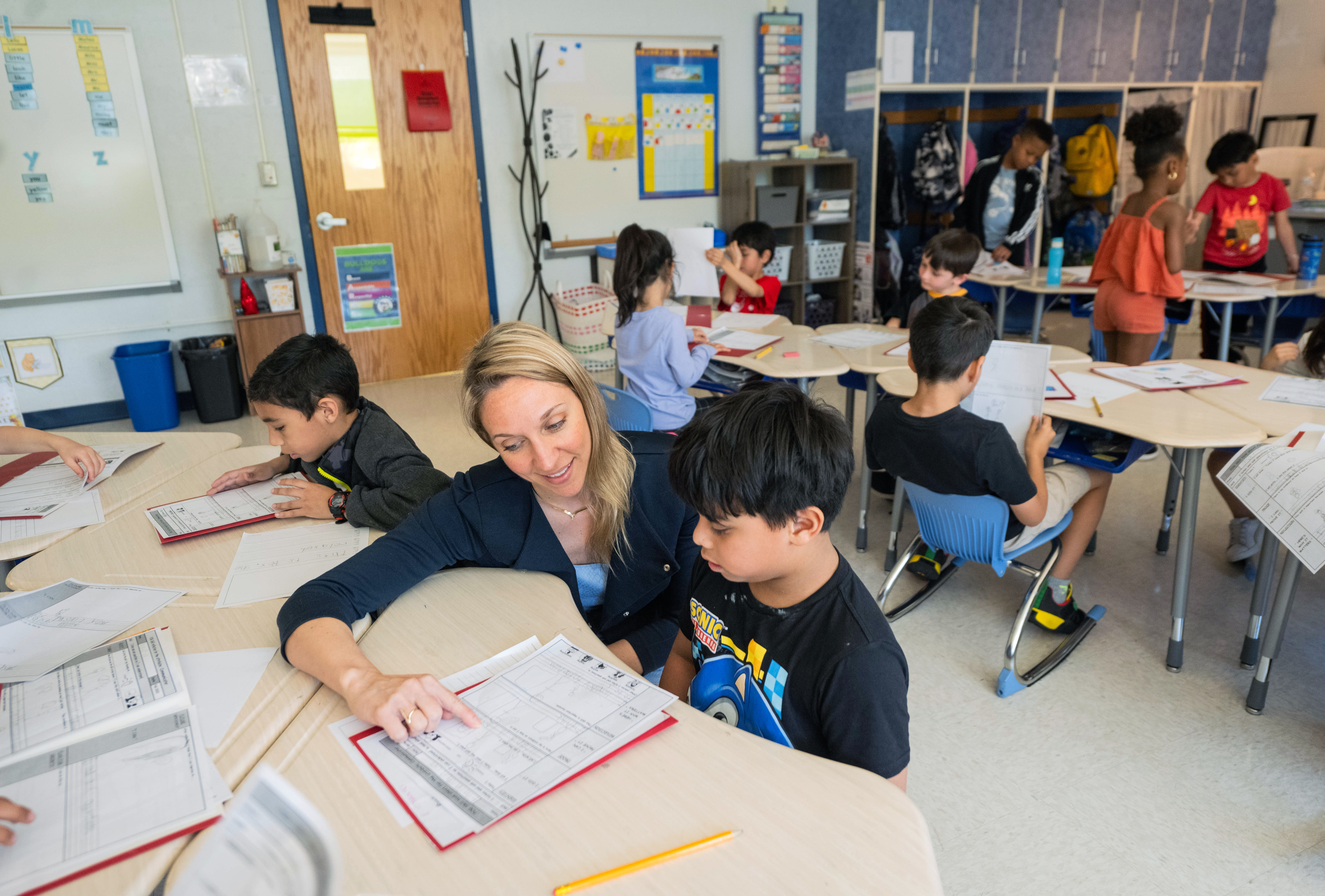 a teacher works at a table with a student. 