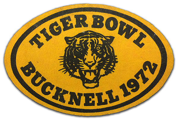 Photograph of an oval-shaped Little League patch from 1972. The felt patch has an illustration of a tiger in black on a gold background. Text around the tiger reads: Tiger Bowl, Bucknell, 1972. 