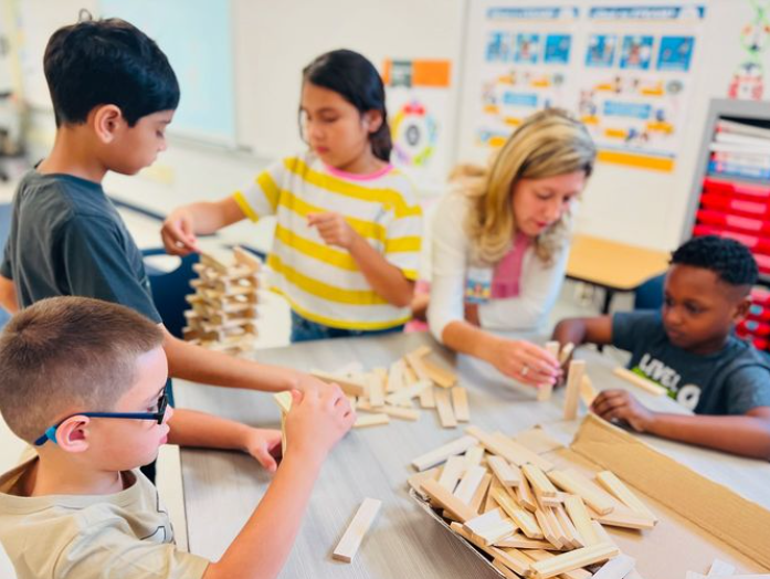 students and teacher working with keva planks